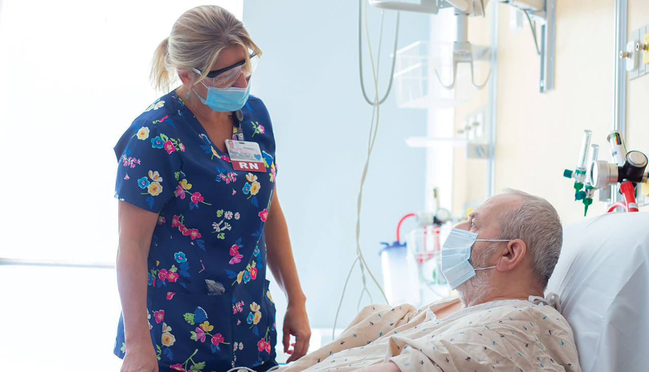 a nurse standing at a patient's bedside