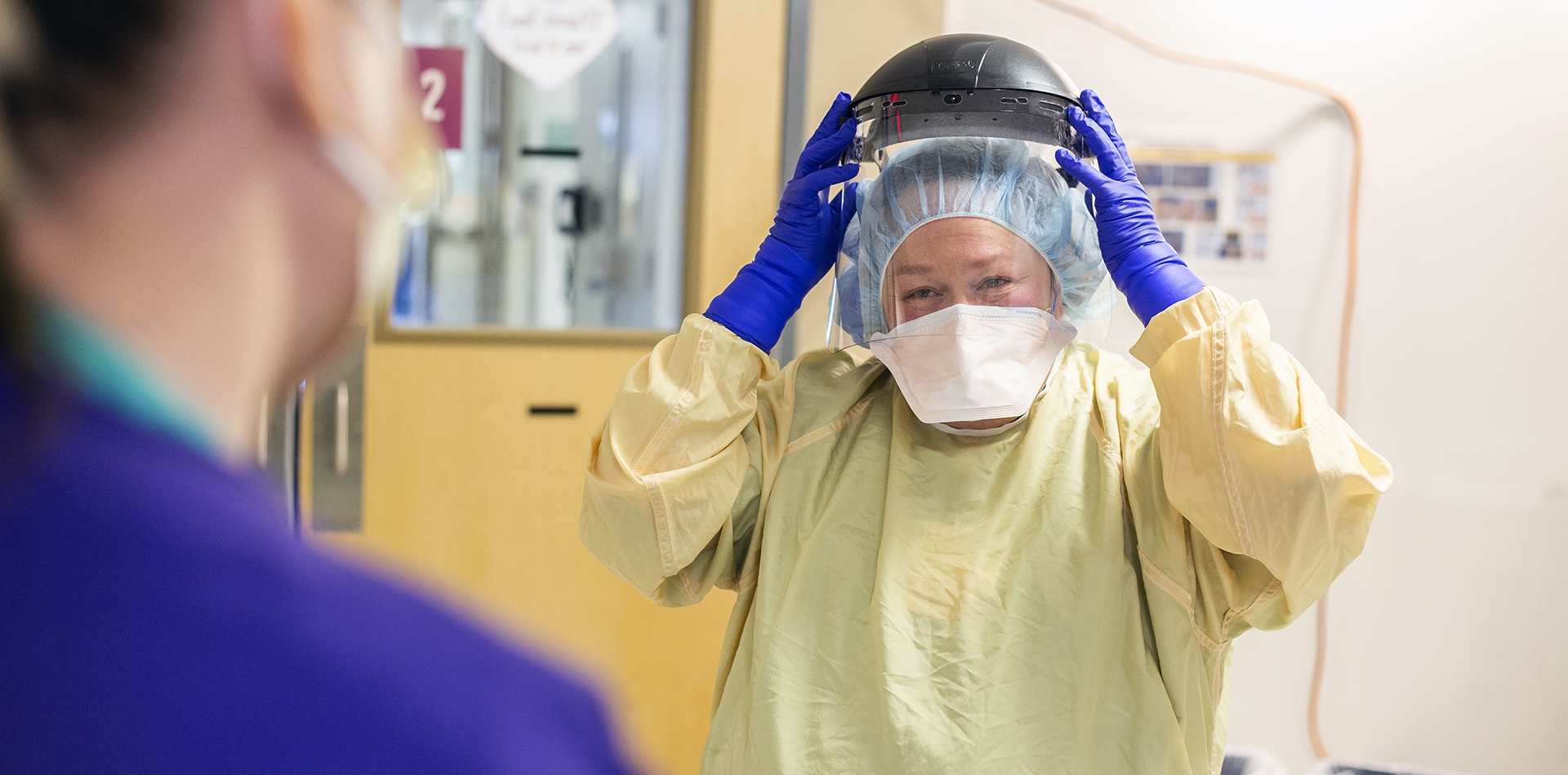 a nurse putting on PPE