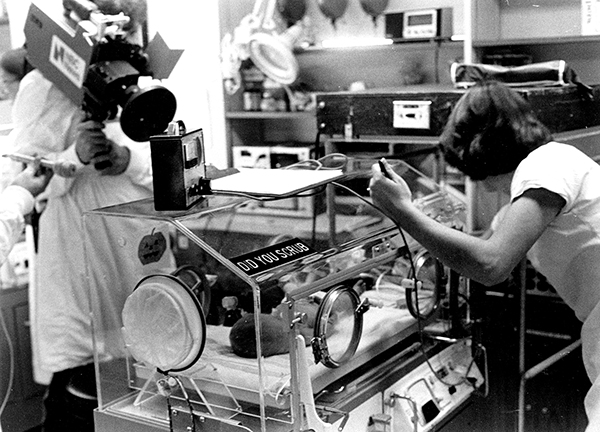 A man filming a NICU nurse with a patient in 1974